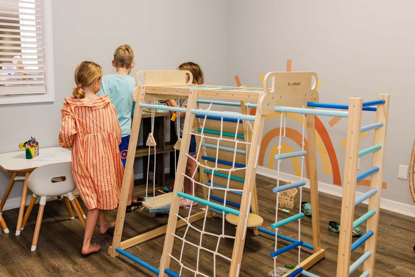 Kids playing on a wooden climbing gym in the office playroom