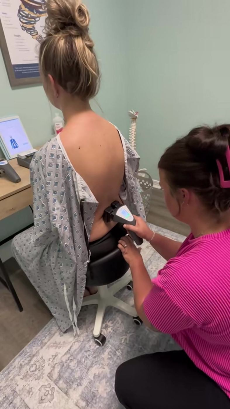 Dr. Kayla running an INSiGHT surface EMG scan along a patient's spine